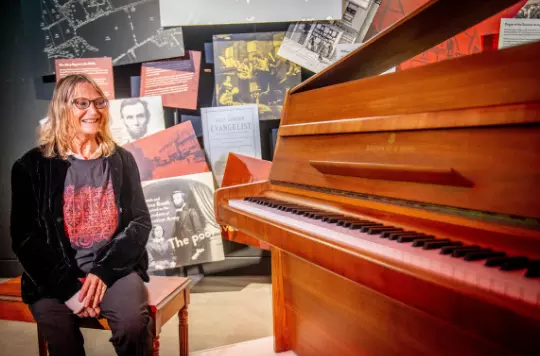 Julia Baird with her brother's 'Imagine' piano