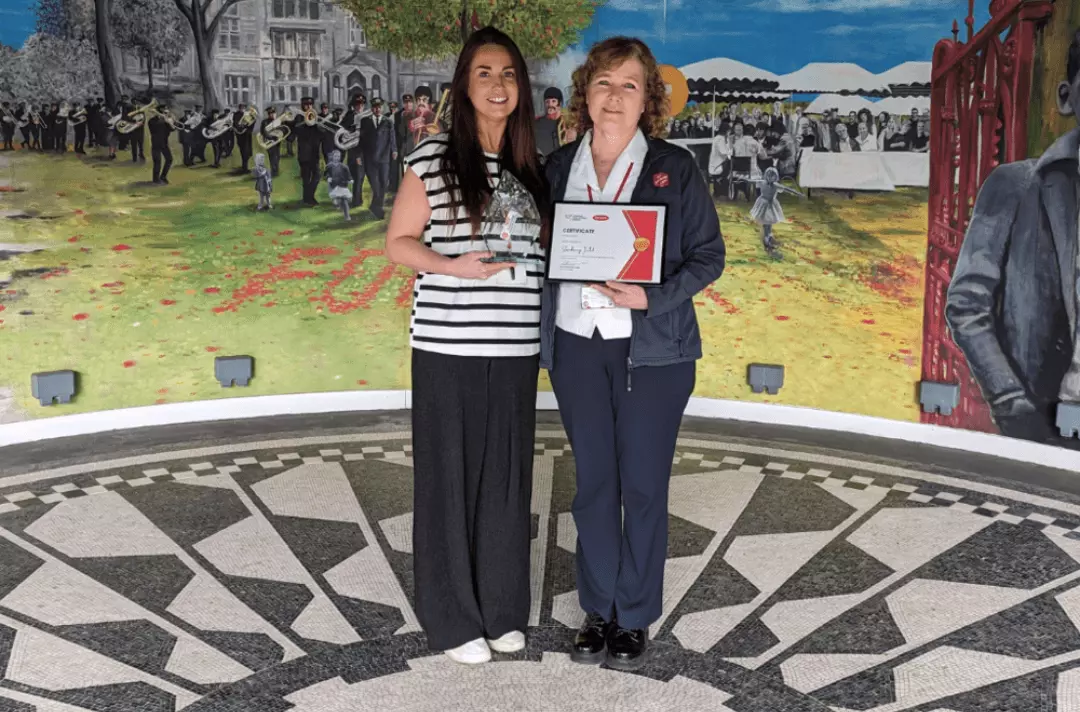 Lynne Furlong and Kathy Versfield stand on the bandstand holding the UniTemps LJMU External Engagement of the Year Award