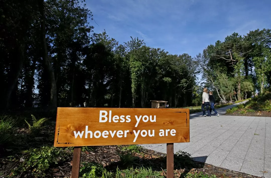 Wooden sign in Strawberry Field garden which says "Bless you whoever you are"