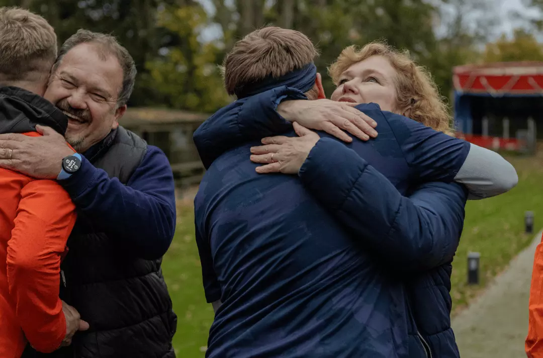Major Allister Versfeld hugs Neil Brannon as Major Kathy Versfeld hugs Martin Quinn