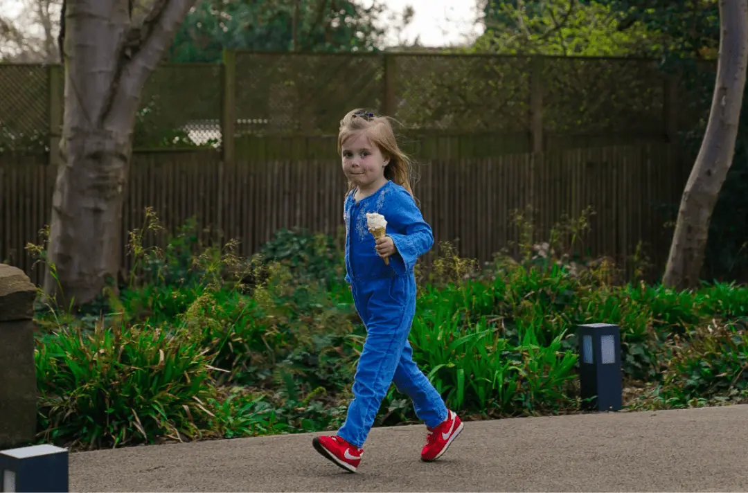 Little girl walking in the Strawberry Field garden with an ice cream