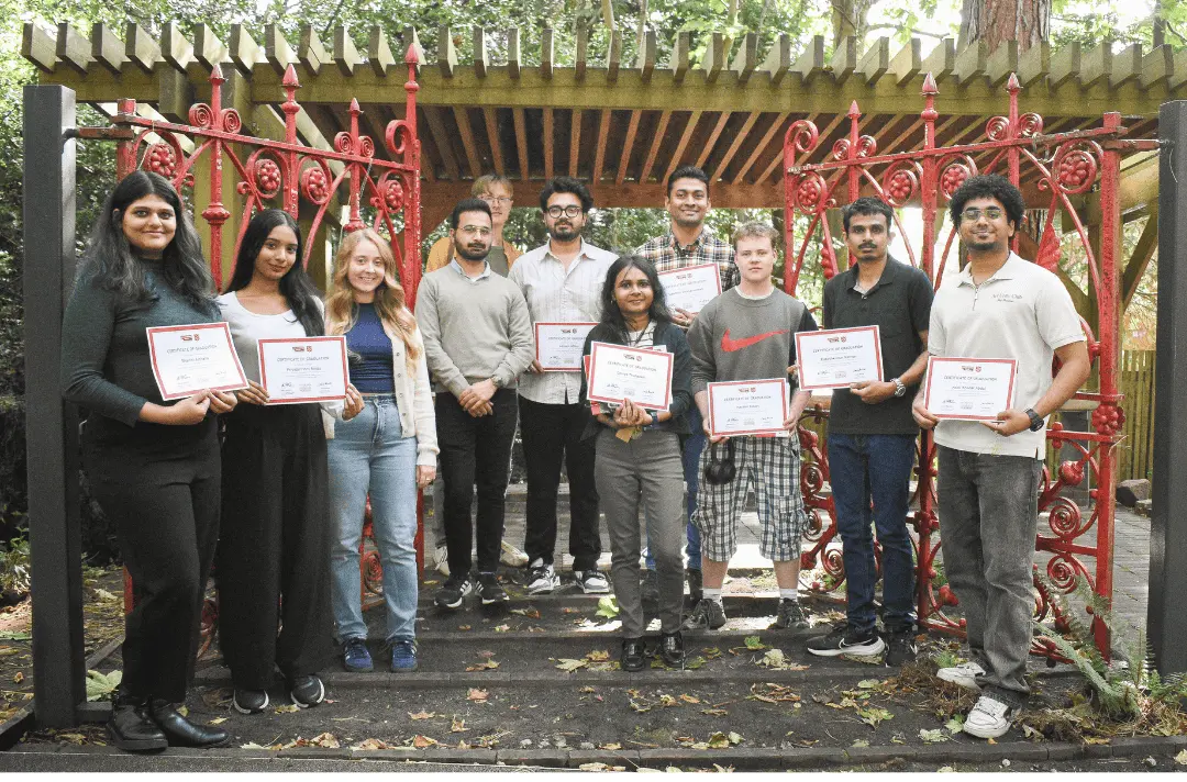 Steps for Students graduates stand between the Strawberry Field gates