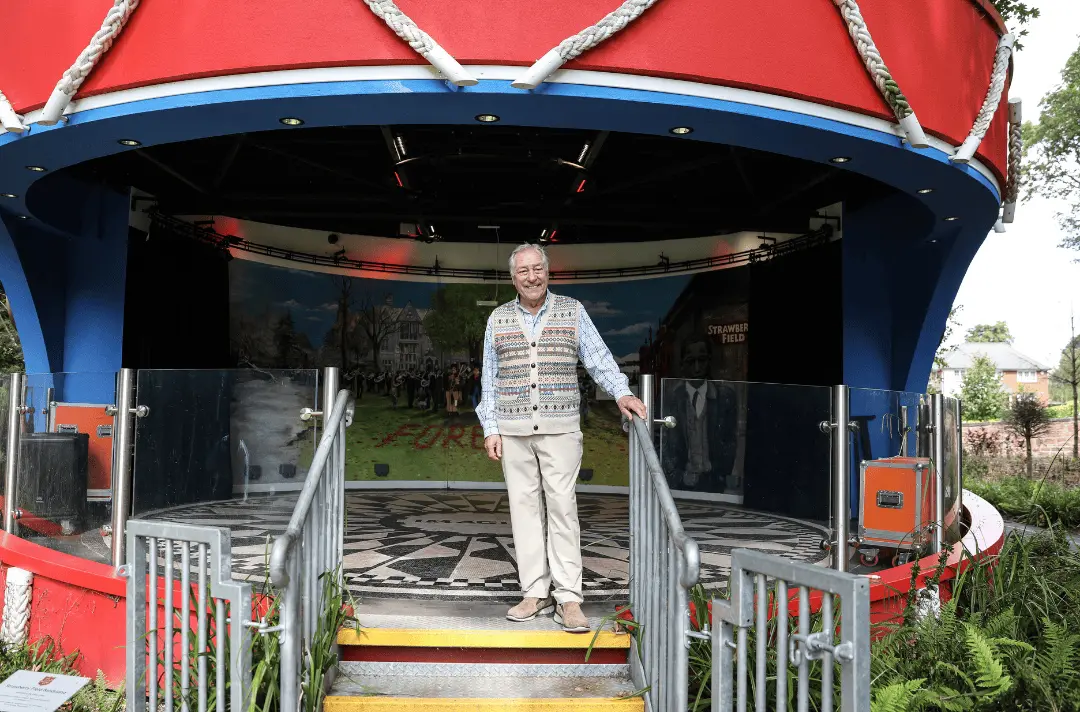 Cliff Cooper, CEO of Orange Amps and Strawberry Field patron, stands smiling on the Sgt Pepper inspired bandstand