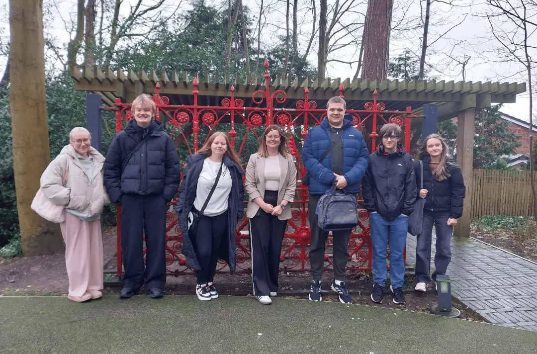 Young people on the Steps to Work programme stand infront of the Strawberry Field gates with Becci Reid, HR Manager at Liverpool John Lennon airport
